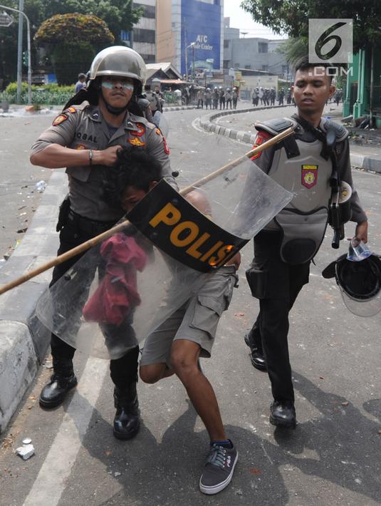 Anggota Sabhara Polri menangkap pengunjuk rasa saat bentrok  dengan massa aksi 22 Mei sebelum terjadi pembakaran bis milik Brimob di kawasan Tanah Abang,  Jakarta, Rabu (22/5/2019). (merdeka.com/Arie Basuki)