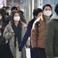 Orang-orang yang mengenakan masker berjalan melalui stasiun kereta api di Seoul, Korea Selatan, Jumat (18/2/2022). Kasus COVID-19 harian Korea Selatan melampaui 100 ribu untuk pertama kalinya. (Jung Yeon-je/AFP)