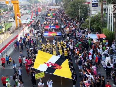 Peserta membentangkan bendera negara anggota ASEAN saat parade ASEAN 50 Tahun di Jakarta, Minggu (27/8). Acara ini merupakan pertunjukan keragaman budaya di Asia Tenggara yang bersatu guna memperingati 50 tahun ASEAN berdiri. (Liputan6.com/Angga Yuniar)