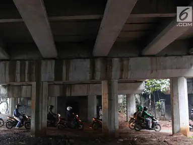 Pengendara motor melintasi jalan setapak di kolong tol di kawasan Lebak Bulus, Jakarta, Selasa (13/2). Untuk menghindari macet sebagian pengendara memanfaatkan jalan setapak tersebut untuk memersingkat waktu tempuh. (Liputan6.com/Immanuel Antonius)