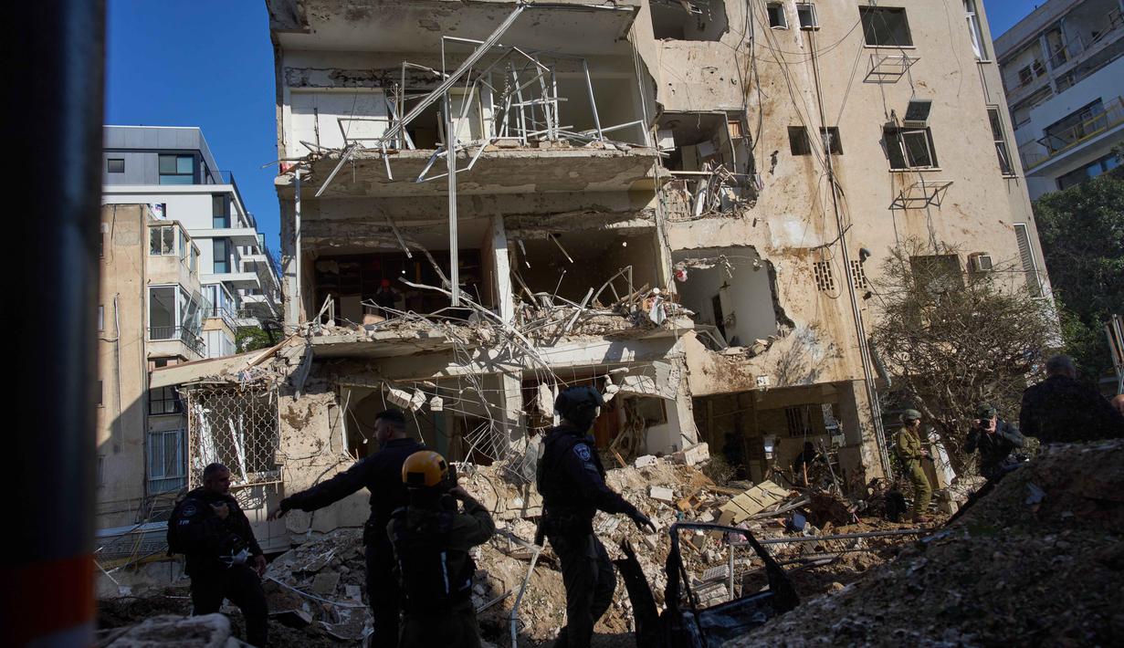 Layanan ambulans Israel melaporkan sedikitnya enam orang cedera dan kerusakan pada gedung berlantai empat setelah serangan berlangsung. Tampak dalam foto, pasukan keamanan Israel dan tim penyelamat memeriksa lokasi serangan rudal Iran di Tel Aviv, Israel, Selasa, 24 Maret 2026. (AP Photo/Oded Balilty)