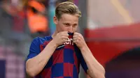 Gelandang asal Belanda Frenkie de Jong mencium logo klub barunya saat pengenalan dirinya sebagai pemain Barcelona di stadion Camp Nou, Spanyol (5/7/2019). Frenkie de Jong sangat antusias bisa bermain dengan sang superstar, Lionel Messi. (AFP Photo/Lluis Gene)