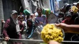 Perserikatan Bangsa Bangsa (PBB), pada Rabu (6/5/2026), memperingatkan bahwa kelaparan masih meluas di seluruh wilayah Gaza. Tampak dalam foto, warga menunggu untuk menerima makanan hangat di kamp pengungsi Palestina, Nuseirat, Jalur Gaza Tengah pada Kamis 7 Mei 2026. (Eyad Baba/AFP)