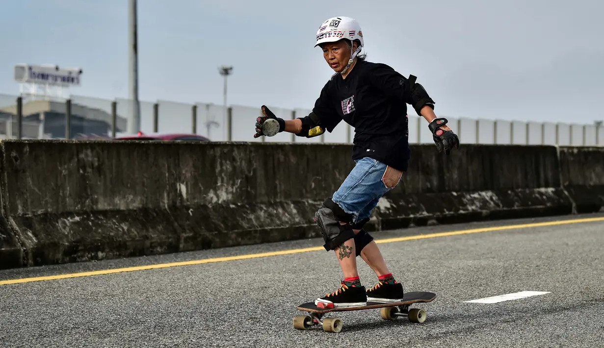 Foto pada 9 September 2020 menunjukkan longboarder dan penderita kanker Nongluck Chairuettichai, juga dikenal sebagai Jeab, selama sesi latihan di jalan raya yang belum selesai di Bangkok. Kegiatan ini dilakukan sebagai jalan pemulihan dari kanker payudara yang dideritanya. (Lillian SUWANRUMPHA/AFP)