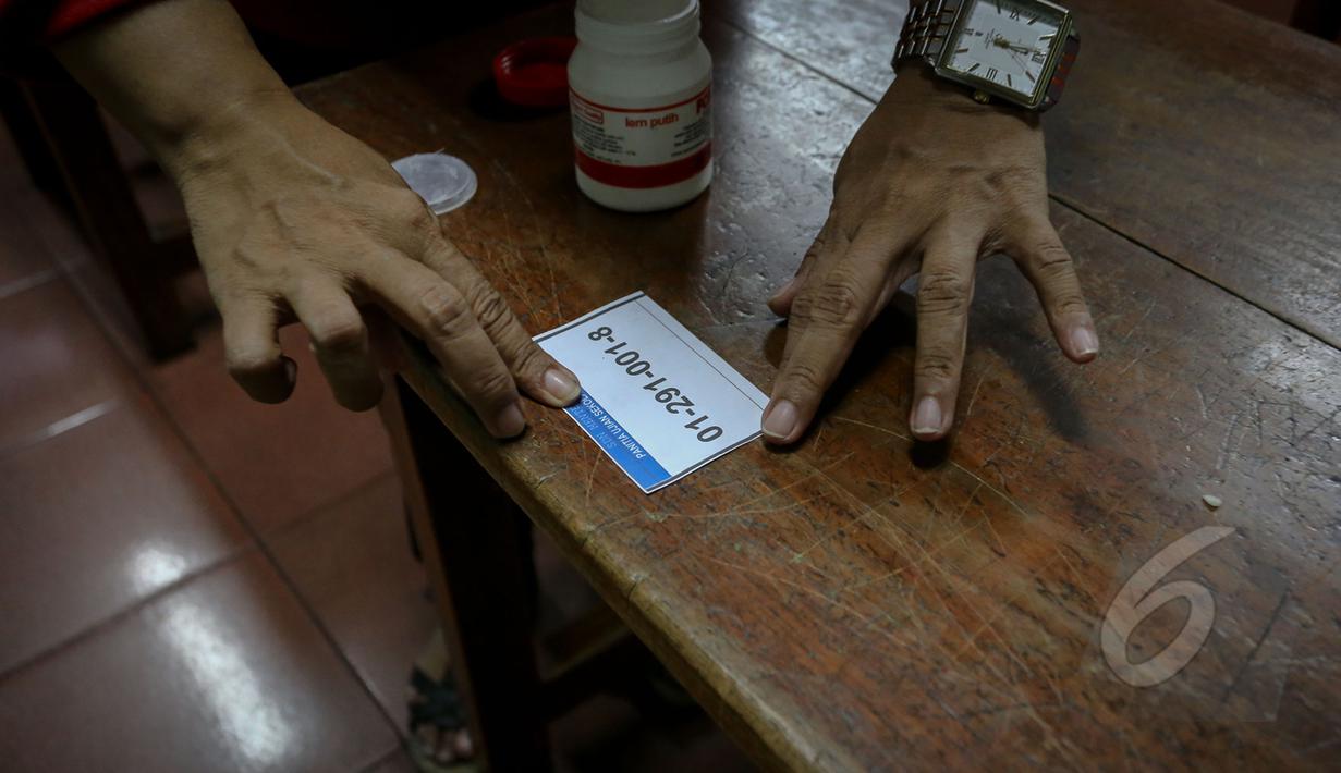Seorang guru saat memasang daftar nomor peserta siswa di ruangan kelas SDN 01 Menteng, Jakarta, Minggu (17/5/2015).  Pelaksanaan UN SD akan dilakukan pada 18-20 Mei mendatang. (Liputan6.com/Faizal Fanani)