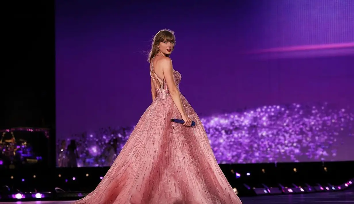 Tak kalah cantik memesona, Taylor Swift tampil dengan gaun berwarna merah muda. Gaun megah ini dipadu dengan rambut berponi yang tergerai dan lipstik merah merona. [Foto: Instagram/taylorswift]