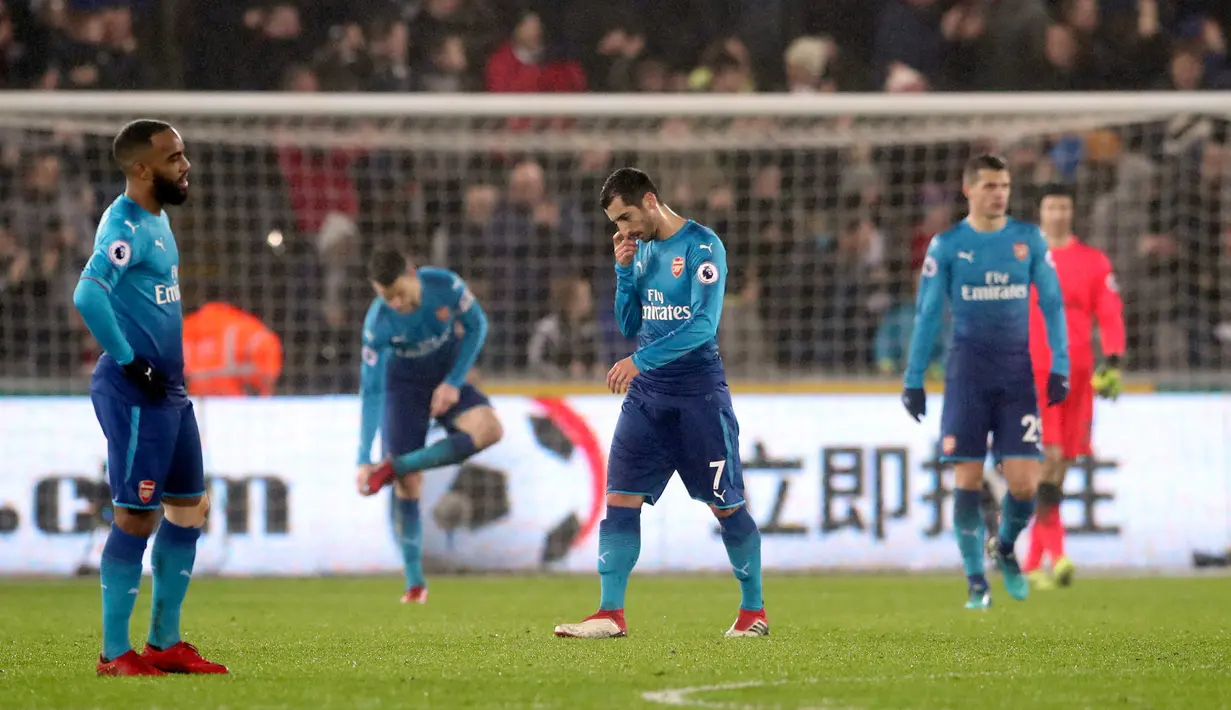 Pemain Arsenal, Henrikh Mkhitaryan (tengah) tertunduk lesu setelah Swansea City mencetak gol ketiga dalam laga pekan ke-25 Premier League 2017-2018 di Liberty Stadium, Selasa (30/1). Arsenal dipaksa menyerah Swansea City 1-3. (Nick Potts/PA via AP)