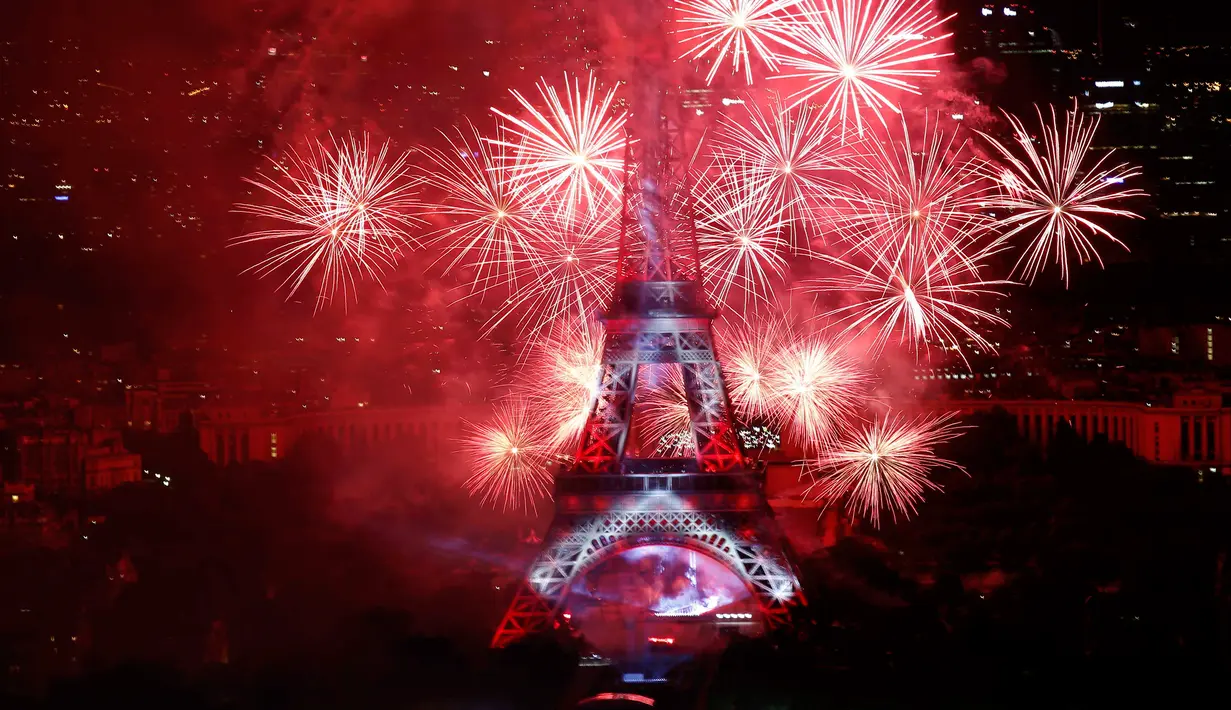 Kembang api menerangi langit di Menara Eiffel saat perayaan tradisional Hari Bastille di Paris, Prancis (14/7). Peringatan ini menandai penyerbuan penjara Bastille pada 14 Juli 1789, yang memicu revolusi Prancis. (REUTERS/Pascal Rossignol)