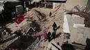 Sementara, anak-anak di Gaza menghias tenda mereka dengan lentera dan ornamen sederhana khas Ramadan. Tampak dalam foto, warga Palestina menggantungkan hiasan Ramadan di samping reruntuhan rumah yang hancur di Khan Younis, Jalur Gaza selatan, Minggu 15 Februari 2026. (AP Photo/Abdel Kareem Hana)