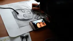 Farhad Nouri (10) menggambar wajah pelukis surealis, Salvador Dali, di kamarnya di dekat Belgrade, Serbia, 13 Maret 2017. Farhad Nouri  bersama orang tua dan dua saudara muda berharap untuk pindah ke Swiss atau Amerika Serikat. (AP/Darko Vojinovic)