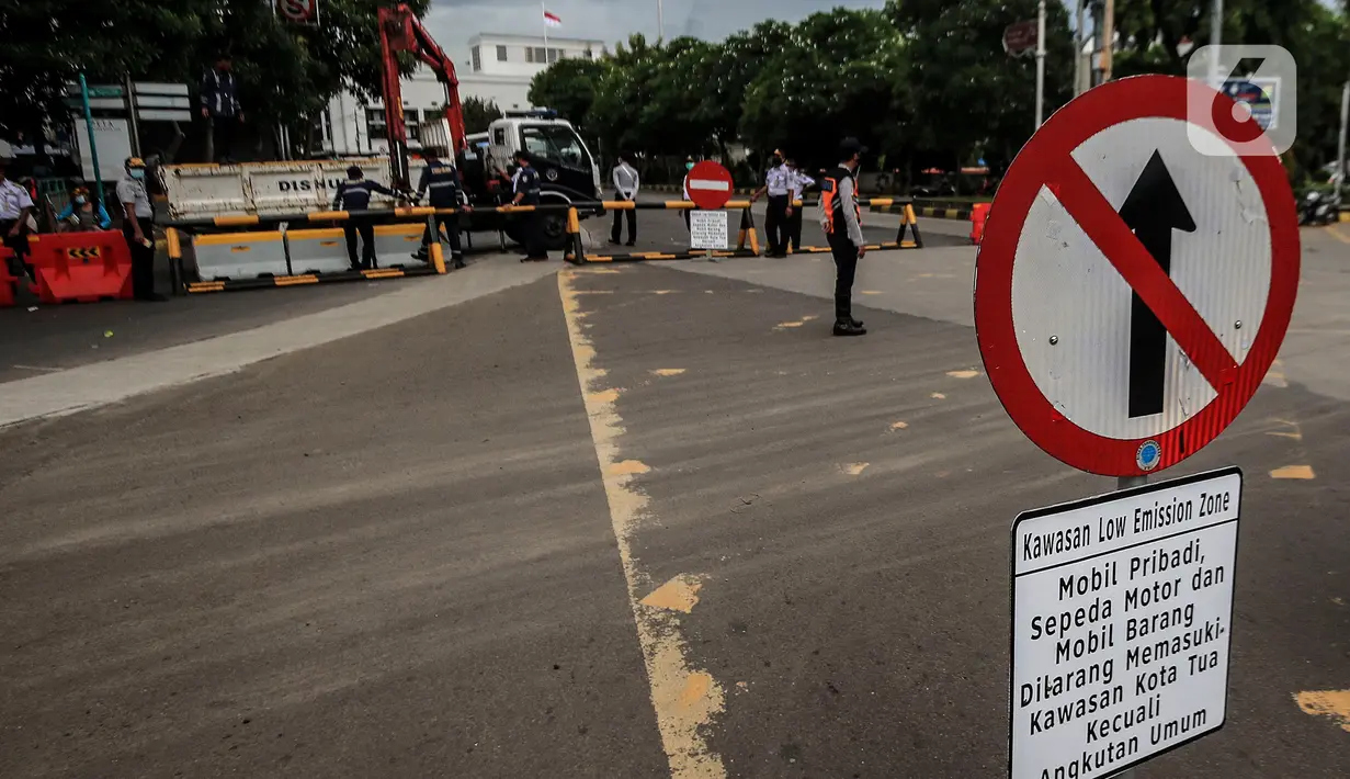Petugas Dinas Perhubungan DKI Jakarta menurunkan beton barrier saat penutupan akses jalan menuju kawasan Kota Tua, Jumat (18/12/2020). Pemprov DKI membatasi moda transportasi melintasi kawasan wisata Kota Tua seiring penerapan kawasan rendah emisi atau Low Emission Zone. (Liputan6.com/Johan Tallo)