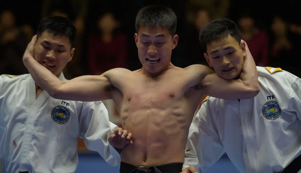 Peserta berusaha mengalahkan lawannya selama demonstrasi taekwondo sebagai bagian dari Kejuaraan Seni Bela Diri Nasional tahunan Mangyongdae di 'Taekwon-Do Hall' di Pyongyang, Korea Utara (9/11). (AFP Photo/Kim Won Jin)