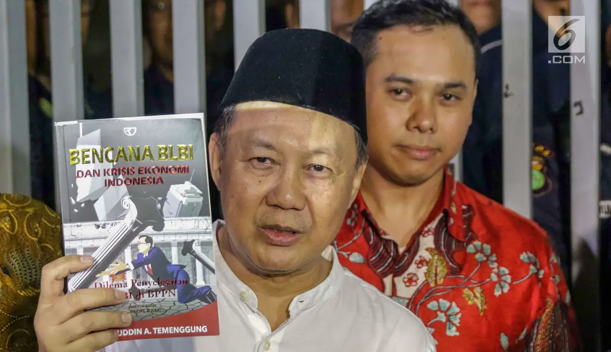 Mantan Kepala BPPN, Syafruddin Arsyad Temenggung menunjukkan buku yang ditulisnya saat meninggalkan Rutan KPK, Jakarta, Selasa (7/9/2019). Sebelumnya, Majelis Hakim Pengadilan Tipikor Jakarta menjatuhi vonis 13 tahun penjara dan denda Rp700 juta. (Liputan6.com/Helmi Fithriansyah)