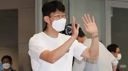 Penyerang Tottenham Hotspur asal Korea Selatan Son Heung-min melambaikan tangan setibanya di Bandara Internasional Incheon (24/5/2022). Son Heung-min dan Mohamed Salah harus rela berbagi gelar top scorer Liga Inggris 2021-2022. (AFP/Yonhap)