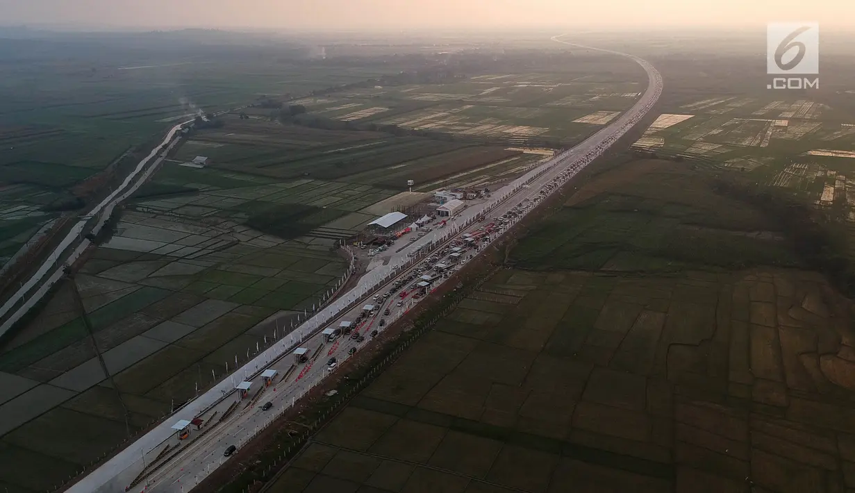 Foto udara antrean kendaraan pemudik di jalur tol fungsional Gerbang Tol (GT) Kertasari, Tegal, Jawa Tengah, Minggu (10/6). Memasuki H-5 lebaran GT Kertasari mulai dipadati kendaraan pemudik dari arah Jakarta. (Liputan6.com/Arya Manggala)