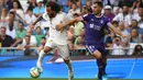Bek Real Madrid, Marcelo, berebut bola dengan bek Valladolid, Javi Moyano, pada laga La Liga di Stadion Santiago Bernabeu, Madrid, Sabtu (24/8). Kedua klub bermain imbang 1-1. (AFP/Gabriel Bouys)
