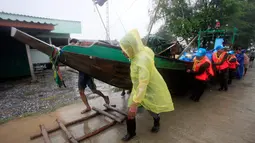 Nelayan memindahkan kapal sebelum Badai Tropis Pabuk mendekat di Pak Phanang, di Nakhon Si Thammarat, Thailand (4/1). Badai akan melanda bagian selatan Thailand dengan hujan lebat, angin, dan gelombang setinggi tujuh meter. (AP Photo/Sumeth Panpetch)