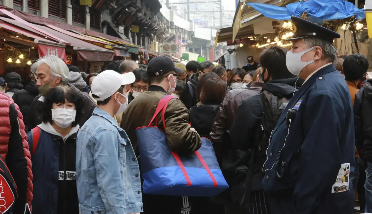 Pengunjung yang memakai masker mengunjungi shopping street Ameyoko untuk membeli bahan masakan Tahun Baru di Tokyo, Selasa (29/12/2020). Tokyo melaporkan peningkatan kasus COVID-19 menjelang musim libur tahun baru, dimana biasanya warga yang tinggal di ibu kota akan mudik. (AP Photo/Koji Sasahara)