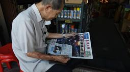 Warga membaca surat kabar dengan berita utama kecelakaan helikopter pemilik Leicester City Vichai Srivaddhanaprabha di Bangkok, Senin (29/10). Bos Leicester City menjadi satu dari lima orang yang tewas ketika helikopternya jatuh. (Lillian SUWANRUMPHA/AFP)