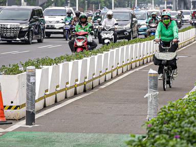 Pesepeda melintasi jalur khusus sepeda yang diberikan pembatas jalur permanen di kawasan Sudirman, Jakarta, Kamis (17/6/2021). Kapolri Jenderal Listyo Sigit Prabowo akan membongkar jalur sepeda di Jalan Sudirman-Thamrin dan mempelajari jalur khusus sepeda di negara lain. (Liputan6.com/Faizal Fanani)