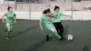 Dua pesepak bola putri klub Beit Umar Palestina berebut bola saat mengikuti sesi latihan di sebuah lapangan di Kota Hebron. (AFP/Hazem Bader)