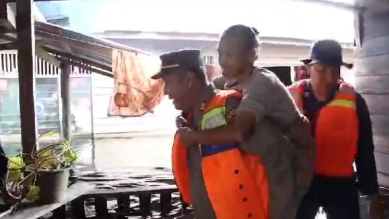 Personel Polres Pelalawan mengevakuasi korban banjir yang terjebak kepungan air setinggi 2 meter lebih.