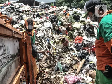 Petugas Sudin LH memilah limbah masker warga di Dipo Sampah Kecamatan Pademangan, Ancol, Jakarta, Rabu (24/2/2021). Sejak April 2020, petugas mengemban tugas baru yang penuh risiko, yakni memisahkan limbah masker warga yang bercampur dengan sampah rumah tangga. (merdeka.com/Iqbal S. Nugroho)