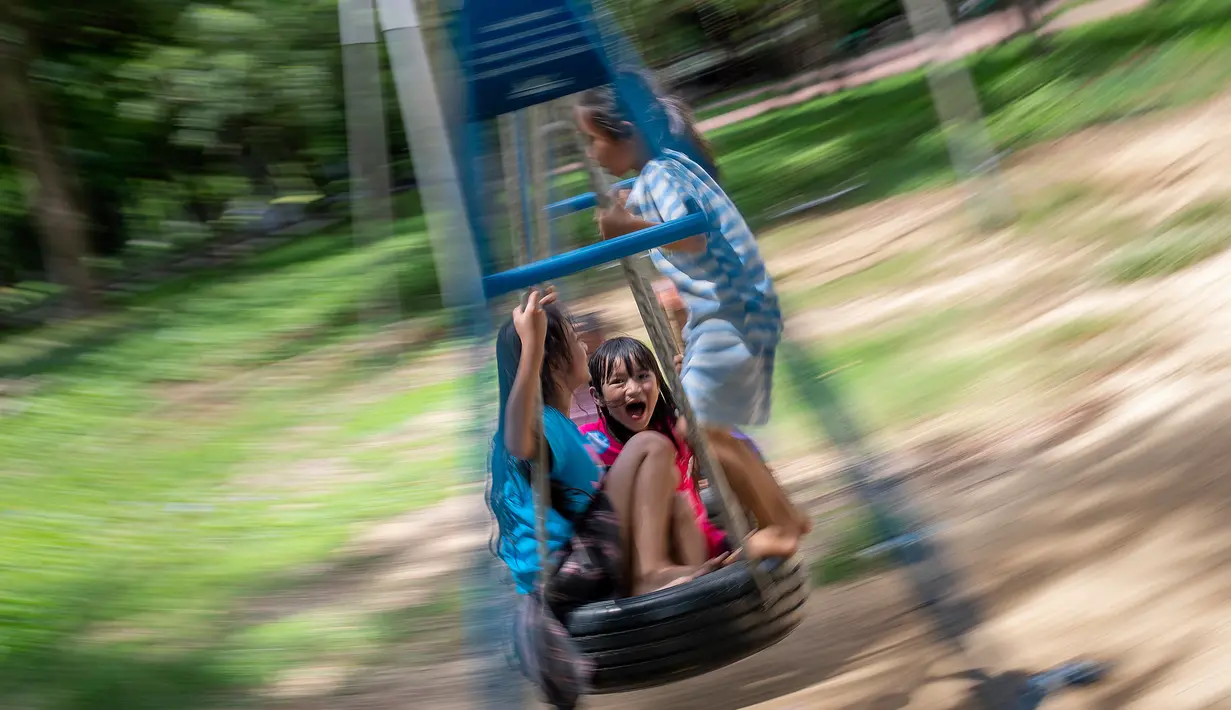 Anak-anak bermain ayunan di taman bermain di Bangkok, Thailand, Rabu (10/6/2020). Pelonggaran pembatasan diberlakukan beberapa minggu lalu untuk memerangi penyebaran COVID-19. (AP Photo/Gemunu Amarasinghe)
