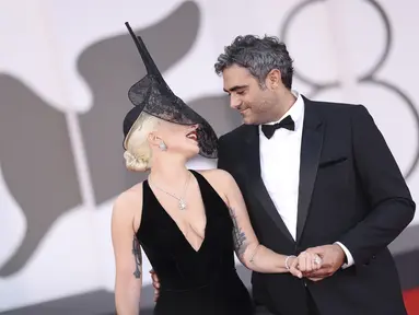 Lady Gaga dan Michael Polansky berpose di depan fotografer saat kedatangannya untuk pemutaran perdana film 'Joker: Folie A Deux' pada Festival Film Venice ke-81 di Venesia, Italia, Rabu (4/9/2024). (Photo by Vianney Le Caer/Invision/AP)