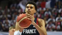 Pebasket Prancis, Victor Wembanyama memegang bola saat Kualifikasi Piala Dunia Basket 2023 melawan Lithuania di Trelaze, Prancis, 26 Februari 2023. Wembanyama saat ini bermain untuk klub Prancis, Boulogne-Levallois Metropolitans 92. Pemain kelahiran 2004 tersebut digadang-gadang menjadi draft pick pertama NBA 2023. (AFP/Jean-Francois Monier)