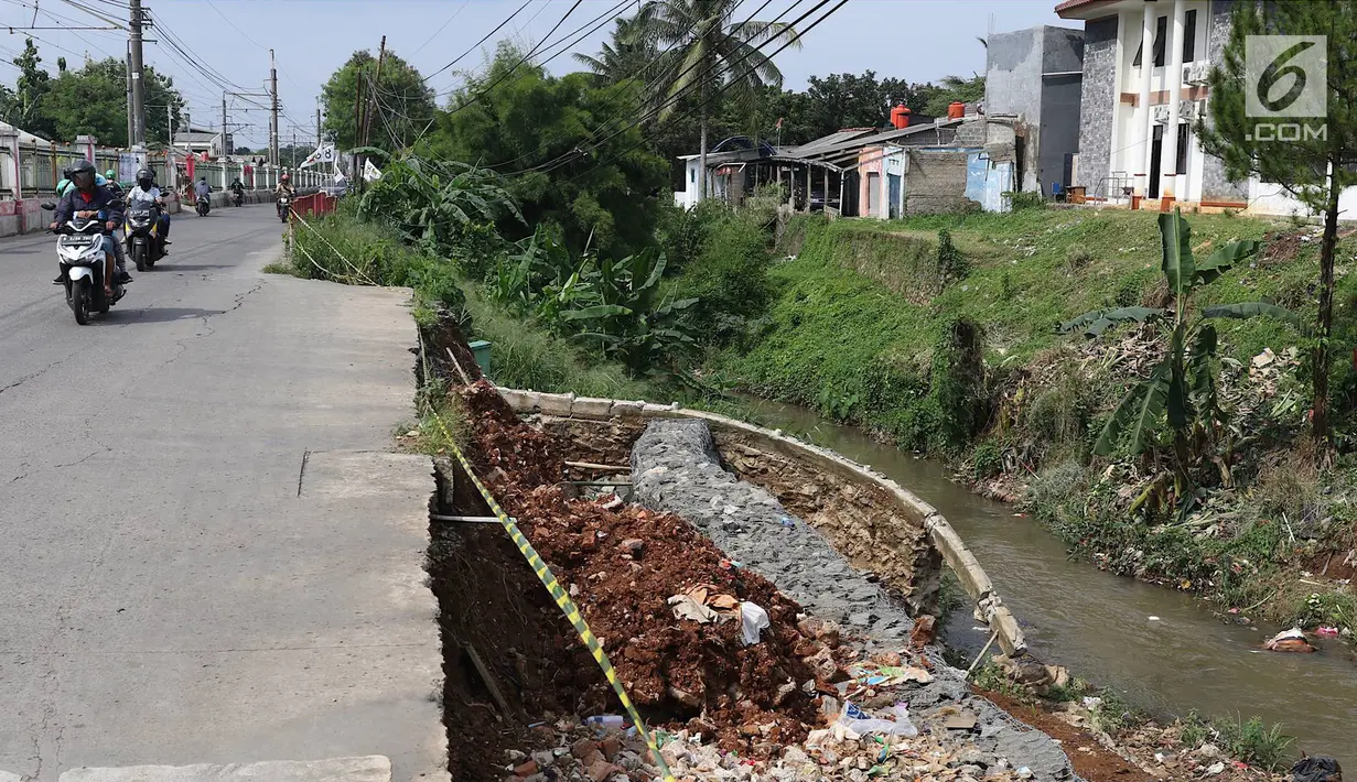 Kendaraan melintas di samping Jalan Raya Citayam yang amblas di kawasan Cipayung, Depok, Jawa Barat, Rabu (27/2). Kondisi tepi jalan yang tidak kunjung diperbaiki membahayakan pengguna jalan terutama saat malam hari. (Liputan6.com/Immanuel Antonius)