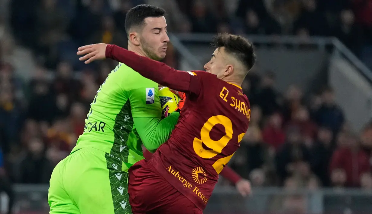 Kiper Verona Lorenzo Montipo (kiri) berebut bola dengan pemain AS Roma Stephan El Shaarawy pada pertandingan sepak bola Liga Italia di Stadion Olimpiade Roma, Italia, 19 Februari 2023. AS Roma mengalahkan Verona dengan skor 1-0. (AP Photo/Andrew Medichini)