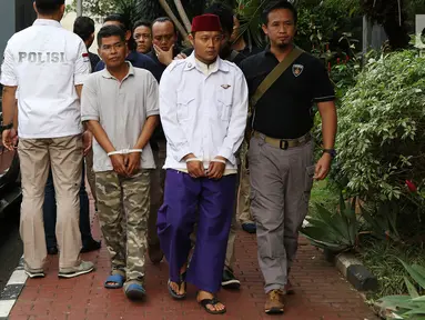 Petugas membawa dua terduga pelaku persekusi U dan M di Polda Metro Jaya, Jakarta, Jumat (2/6). Reskrim Polres Jaktim menangkap dua pelaku persekusi terhadap PMA, 15 tahun, karena diduga menghina FPI dan Rizieq Syihab. (Liputan6.com/Immanuel Antonius)