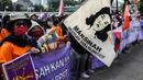 Sejumlah buruh perempuan memegang poster saat menggelar aksi di depan gedung DPR RI, Jakarta, Selasa (8/3/2022). Mereka menuntut dibatalkannya Omnibus Law UU Cipta Kerja dan mendesak agar RUU Tindak Pidana Kekerasan Seksual (TPKS) segera disahkan oleh DPR RI. (Liputan6.com/Johan Tallo)