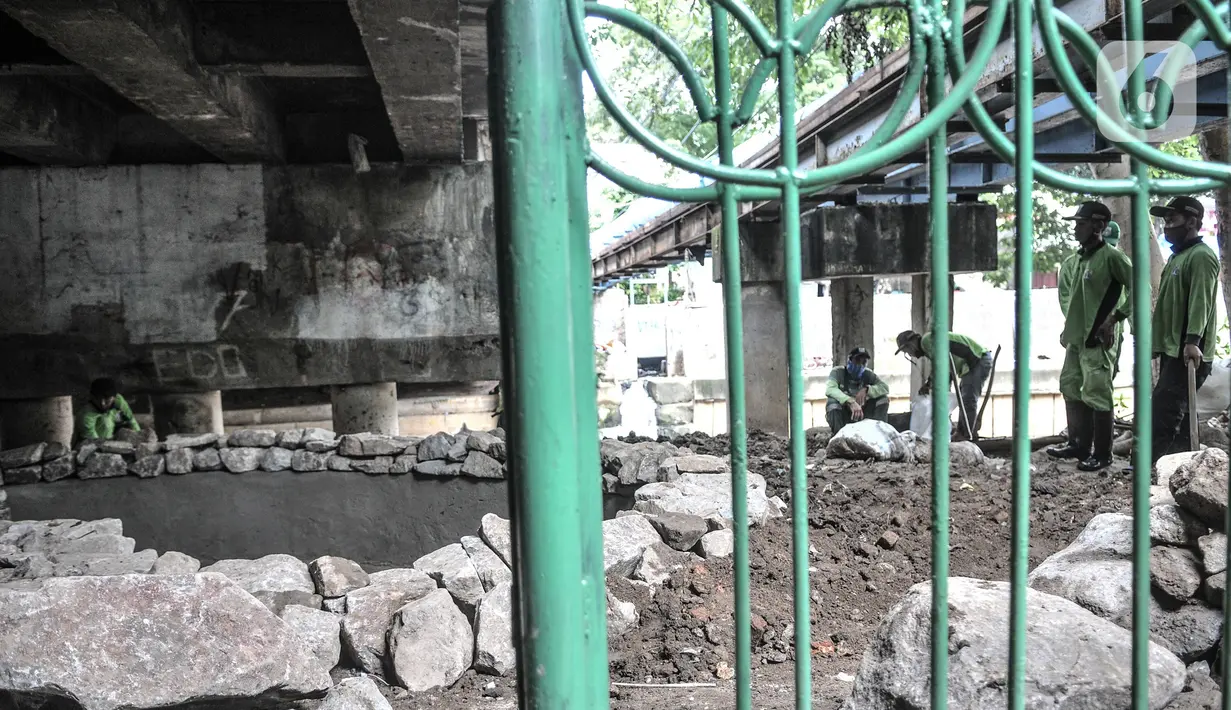 Petugas Suku Dinas Pertamanan Jakarta Pusat menyelesaikan pembangunan taman di kolong Jembatan Pegangsaan, Jakarta, Selasa (19/1/2021). Kolong jembatan yang sebelumnya dihuni oleh tunawisma tersebut kini diubah menjadi taman. (merdeka.com/Iqbal S. Nugroho)