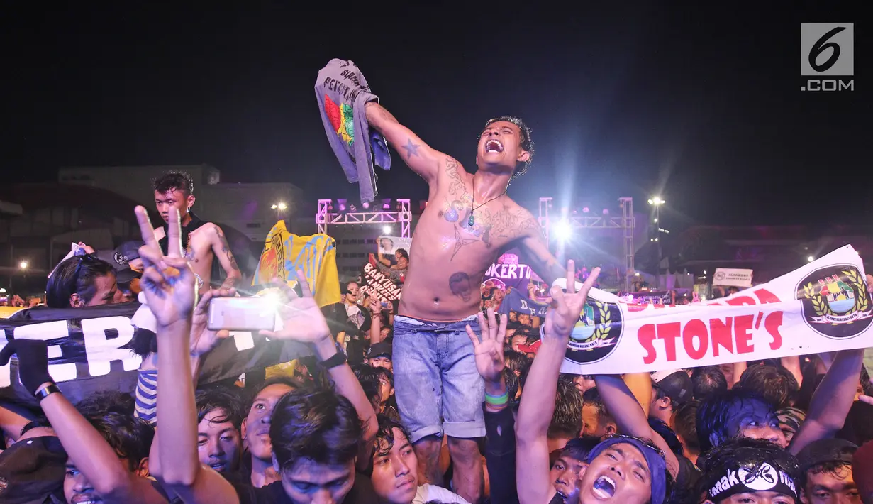 Aksi slankers dalam konser perayaan ulang tahun ke-34 Slank di JIExpo Kemayoran, Jakarta, Selasa (26/12). Konser ini menjadi yang paling ditunggu setelah lima tahun Slank tak menggelar konser ulang tahun di tempat umum. (Liputan6.com/Herman Zakharia)