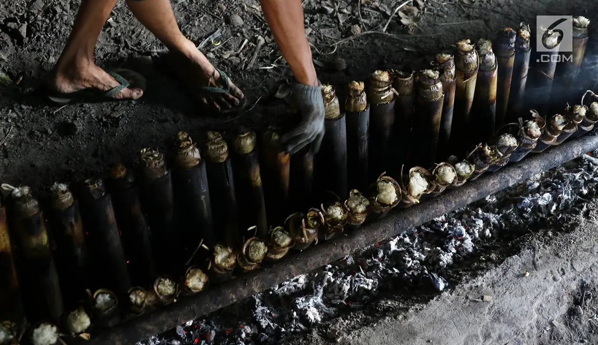 Pekerja memasak lemang menggunakan bambu di kawasan Senen, Jakarta, Selasa (30/5). Memasuki bulan Ramadan, produksi panganan khas dari Sumatera Barat tersebut meningkat 500% yang dijual seharga Rp13.000 perbuah. (Liputan6.com/Immanuel Antonius)