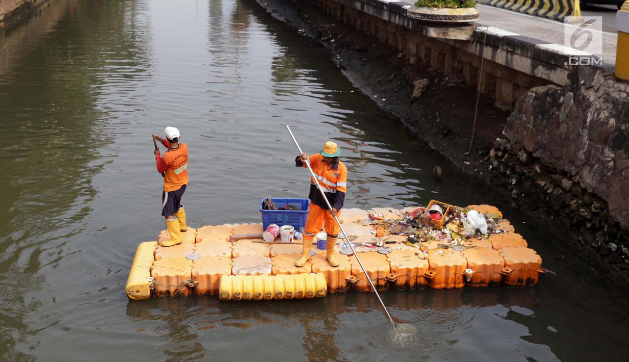 Petugas UPK Badan Air Pemprov DKI Jakarta membersihkan ceceran sampah di sepanjang Anak Sungai Ciliwung yang membelah kawasan Jalan Gajah Mada dan Hayam Wuruk, Selasa (9/7/2019). Pembersihan ini untuk menghindari penumpukan sampah dan memperlancar aliran air. (Liputan6.com/Helmi Fithriansyah)