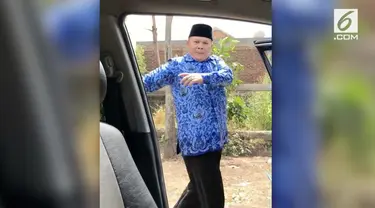 Seorang pria yang memakai seragam PNS dan berpeci melakukan joget ala tantangan 'Kiki Challange'.