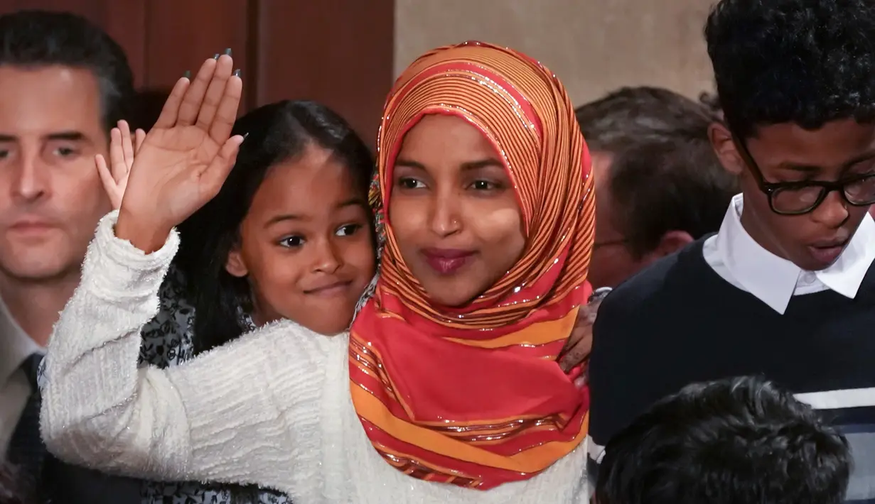 Senator Amerika Serikat (AS) Ilhan Omar melambaikan tangan saat mengikuti pelantikan di Gedung Kongres AS, Capitol, Washington, Kamis (3/1). Omar adalah perempuan berhijab pertama yang masuk ke Senat AS. (Glen Stubbe/Star Tribune via AP)