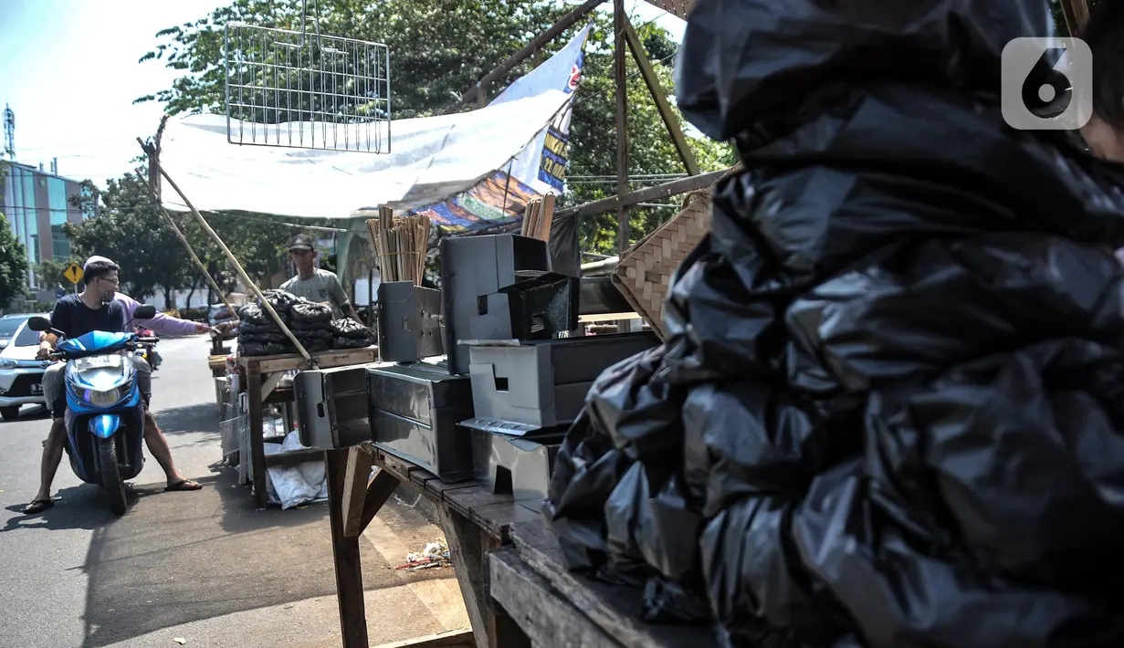 Pedagang arang melayani pembeli di kawasan Manggarai, Jakarta Selatan, Minggu (10/7/2022). Perayaan Idul Adha membawa berkah tersendiri bagi para pedagang arang musiman di kawasan Manggarai karena banya warga membeli untuk tradisi membakar sate. (merdeka.com/Iqbal S. Nugroho)