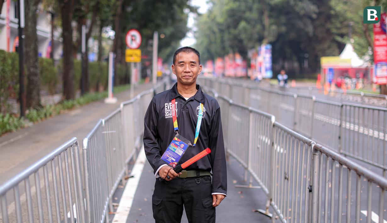 Ipal Mustakin merupakan salah satu petugas keamanan di Piala Dunia FIBA 2023. Ia bertugas di bagian pintu masuk loket Indonesia Arena. Pekerjaannya adalah untuk memastikan keamanan dan menertibkan antrean penonton yang akan menyaksikan pertandingan. Ipal sendiri sehari-hari bekerja sebagai pedagang. (Bola.com/Bagaskara Lazuardi)