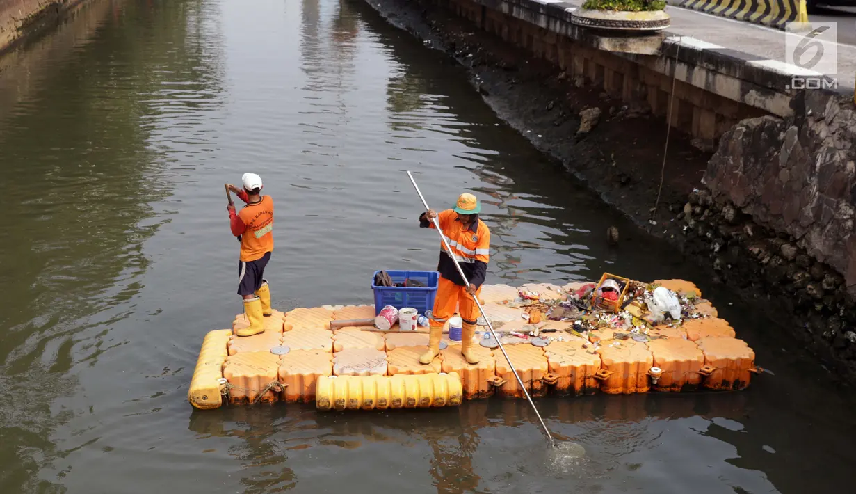 Petugas UPK Badan Air Pemprov DKI Jakarta membersihkan ceceran sampah di sepanjang Anak Sungai Ciliwung yang membelah kawasan Jalan Gajah Mada dan Hayam Wuruk, Selasa (9/7/2019). Pembersihan ini untuk menghindari penumpukan sampah dan memperlancar aliran air. (Liputan6.com/Helmi Fithriansyah)