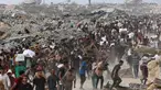 Orang-orang membawa bantuan berjalan di sepanjang jalan al-Rashid di Jabalia barat pada 22 Juni 2025, setelah truk bantuan kemanusiaan memasuki Jalur Gaza utara melalui perbatasan Zikim yang dikuasai Israel, di tengah perang yang sedang berlangsung antara Israel dan Hamas. (Omar AL-QATTAA/AFP)