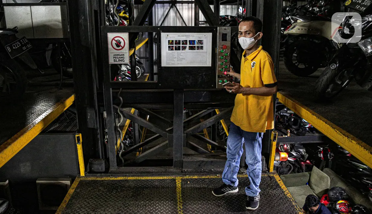 Pekerja mengakses kontrol saat akan menurunkan sepeda motor di Soul Parking, Kebon Kacang, Jakarta, Jumat (21/1/2022). Tempat parkir vertikal tersebut menerapkan sistem teknologi Compact Motor Storage atau sistem rak bersusun dengan lift barang. (Liputan6.com/Faizal Fanani)