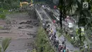 Warga beramai-ramai menyaksikan aliran lahar dingin yang melintasi Sungai Yeh Sah di Karangasem, Bali, Sabtu (2/12). Banjir lahar dingin dari Gunung Agung tersebut mengundang perhatian warga sekitar. (Liputan6.com/Immanuel Antonius)