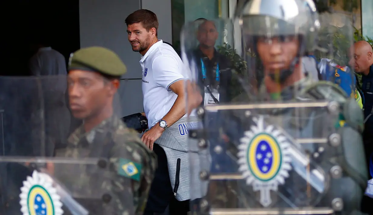 Punggawa Timnas Inggris, Steven Gerrard, terlihat berjalan di belakang pagar betis militer Brasil di Rio de Janeiro, (8/6/2014). (REUTERS/Eddie Keogh)