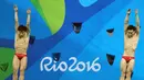 Atlet Tiongkok, Atlet dan Qin Kai saat mengikuti loncat indah sinkronisasi 3 m pria pada Olimpiade 2016 di Brasil, (10/8). Dalam cabang olahraga ini setiap negara harus memiliki 2 peserta.  (REUTERS/Antonio Bronic)