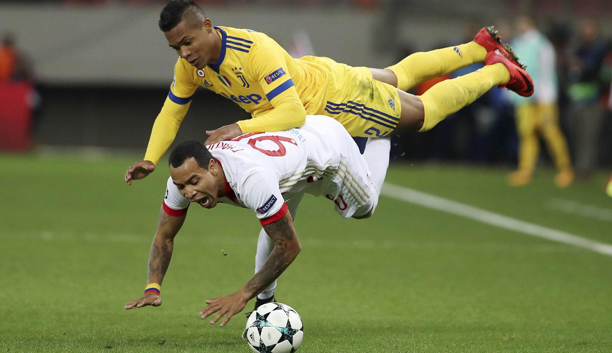 Gelandang Olympiakos,  Felipe Pardo, terjatuh saat berebut bola dengan bek Juventus, Alex Sandro, pada laga Liga Champions di Stadion Georgios Karaiskakis, Rabu (6/12/2017). Juventus menang 2-0 atas Olympiakos. (AFP/Petros Giannakouris)