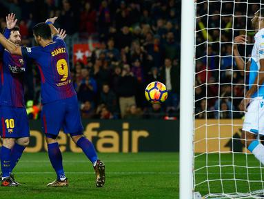 Pemain Barcelona, Lionel Messi merayakan gol rekan setimnya, Luis Suarez ke gawang Deportivo La Coruna pada pertandingan pekan ke-16 La Liga di Stadion Camp Nou, Senin (18/12). Barcelona unggul 4-0 lewat dua gol Suarez.  (AP/Manu Fernandez)
